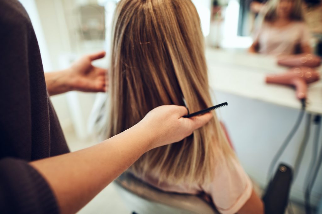 Woman getting her hair cut by a salon hairstylist